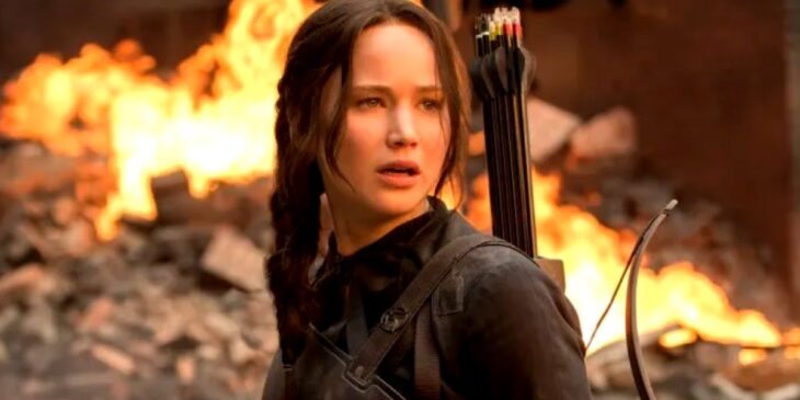 Katniss Everdeen em cenário caótico de Jogos Vorazes