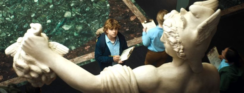 Percy Jackson observando estátua de Perseu