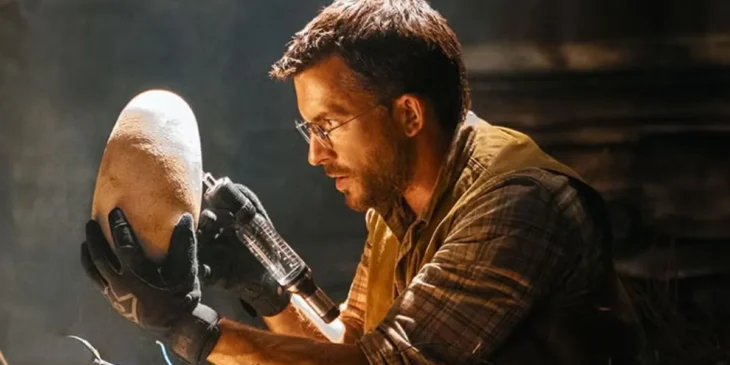 Jonathan Bailey com um ovo de dinossauro em Jurassic World Recomeço