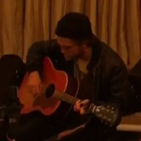 O ator Robert Pattinson com um violão