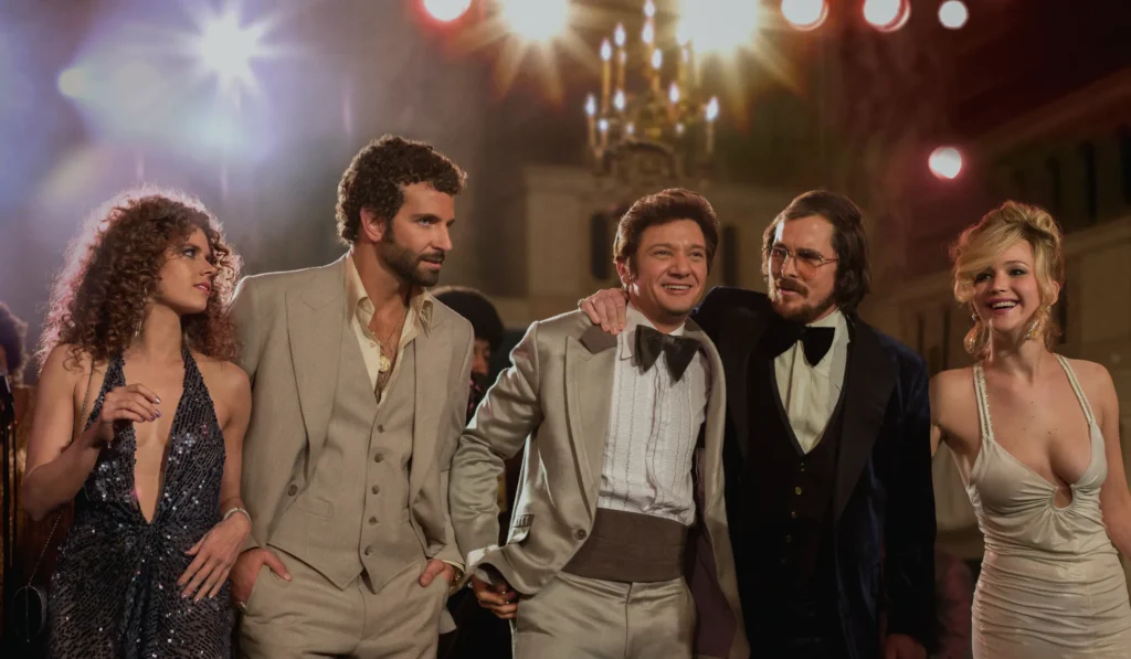 Amy Addams, Bradley Cooper, Jeremy Renner, Christian Bale e Jennifer Lawrence em Trapaça